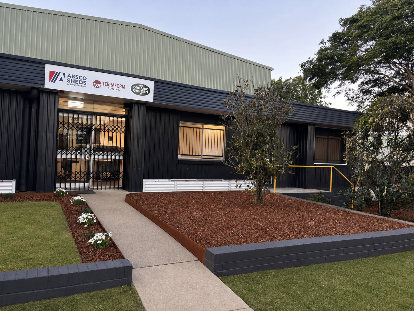 Commercial landscaping with mulched garden beds, steel edging and new turf