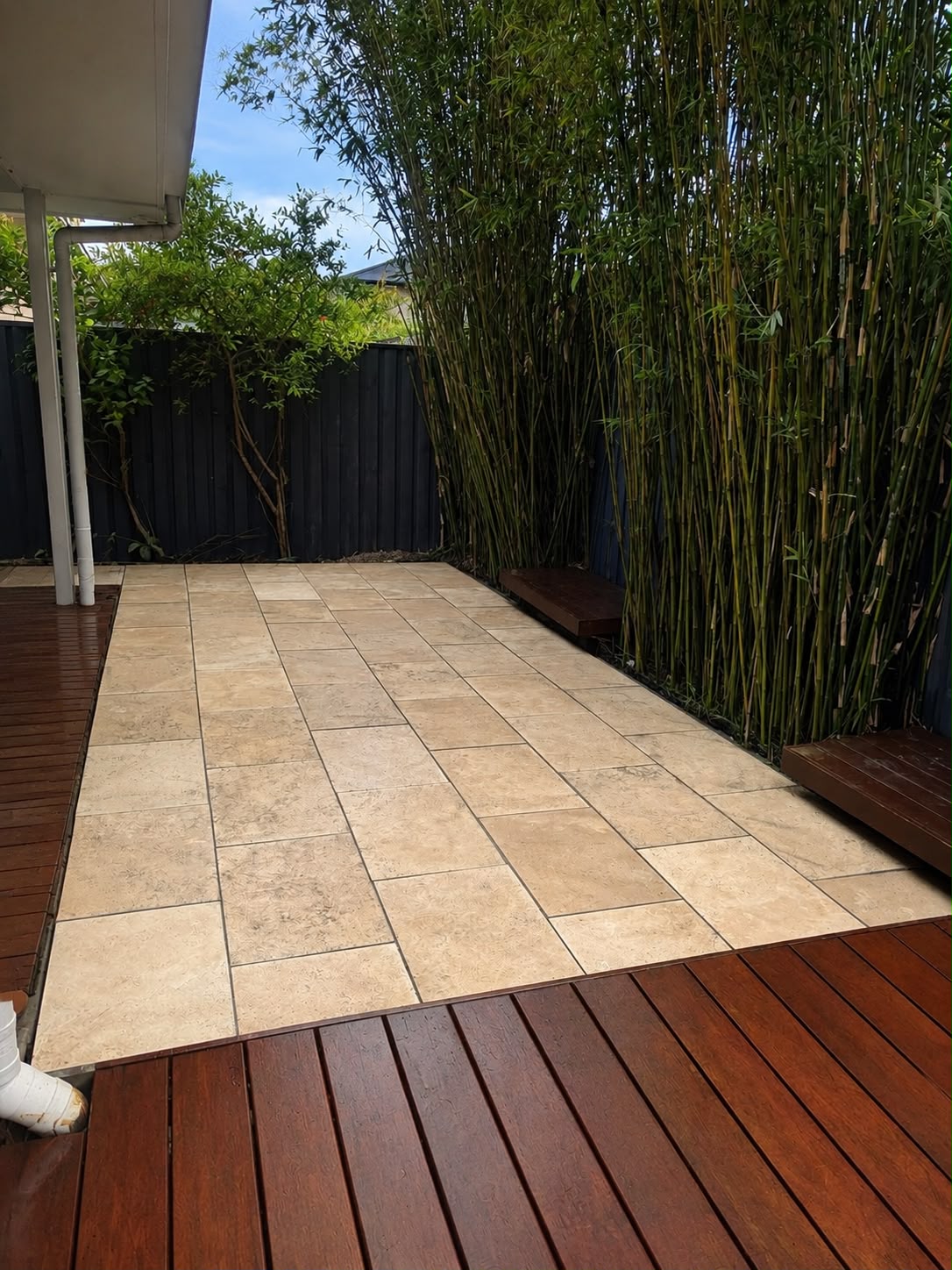 Paved outdoor courtyard with bamboo screening and hardwood decking