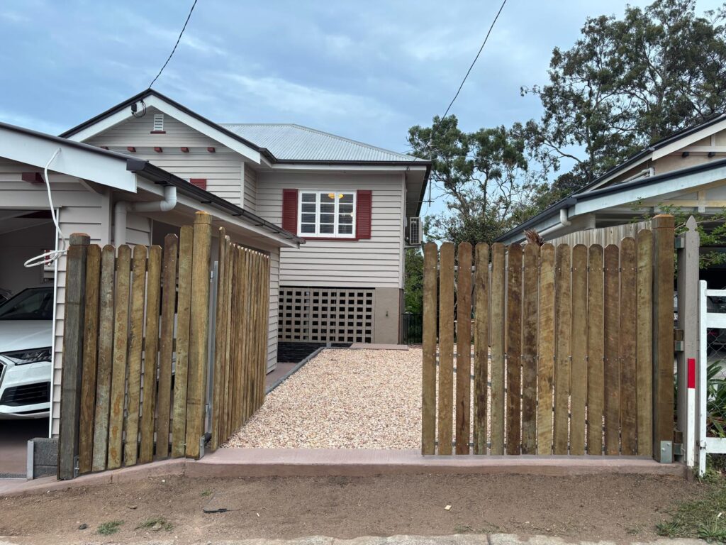 Hardwood driveway gates partially open in Tarragindi