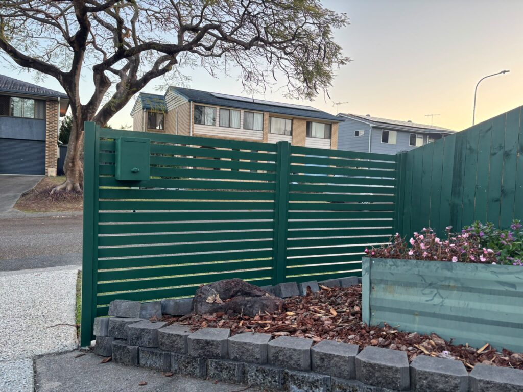 Custom Cottage Green slat panels beside a stepped garden bed in Oxley