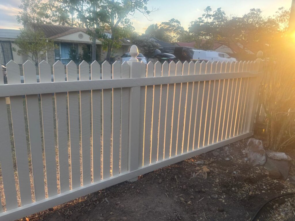 Inside view of the painted hardwood fence in evening sunlight in Forest Lake