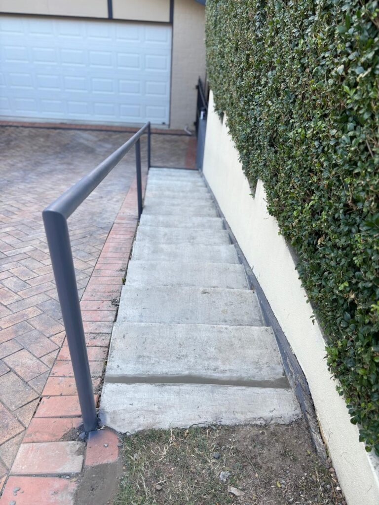 Concrete stairs with a metal handrail.